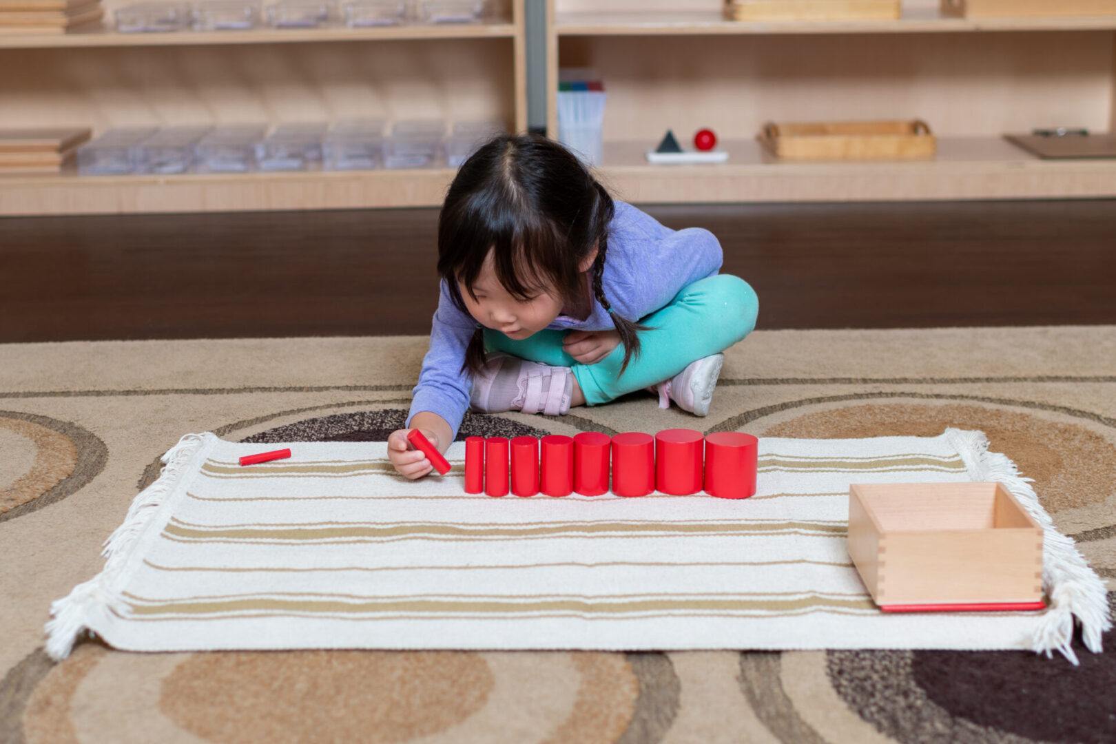 A cute little girl playing with wooden blocks